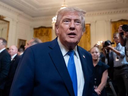 President Donald Trump speaks with a reporter as he departs after an event for Olympic athletes, coaches, staff, and representatives from Team USA in the East Room of the White House, Thursday, Aug. 6, 2026, in Washington. (AP Photo/Alex Brandon)