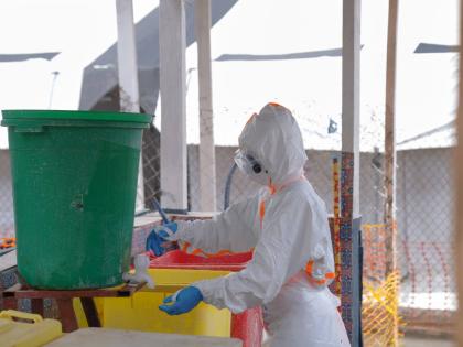 A health worker in protective gear washes her hands at the treatment centre in Bunia General Hospital in Ituri, eastern Congo, on Tuesday.