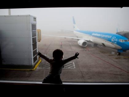 A child watches a plane at the Jorge Newbery Airport in Buenos Aires, Argentina, April 14, 2016. 