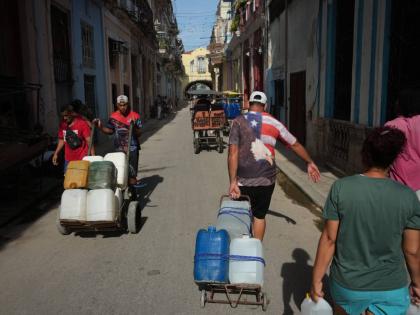 People carry water during a power outage in Havana, Cuba.