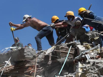 Residents and rescue workers search through the rubble after an earthquake struck Cali, Colombia, last Monday.