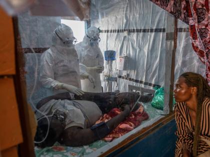 Health workers tend to an Ebola patient at the Rwampara Treatment Center in Ituri, Congo.
