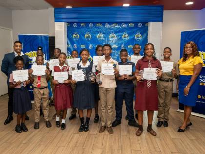 Bert Tomlinson Jr (left), director, Bert’s Auto Parts Foundation, and Roxanne Edwards-Chambers (right), junior human resources officer, Bert’s Auto Parts, celebrate with 16 young achievers receiving scholarships and grants from the foundation as part o