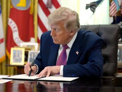 President Donald Trump signs an executive order in the Oval Office of the White House, Thursday.
