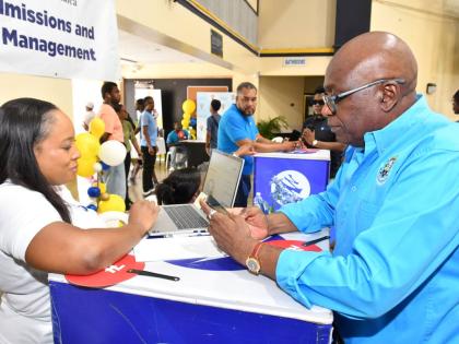 Russchanie Douglas (left), senior relationship manager at Mayberry Investments Limited, interacts with Paulton Gordon, community development director at the University of Technology, Jamaica. The two connected at the UTech ‘Week of Welcome’ Orientation