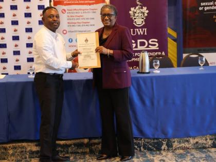 Conrad Saunders, programme coordinator at the Ministry of Labour and Social Security, receives a certificate from Dr Jennifer Brown-Tomlinson, medical director, Jamaica AIDS Support for Life.