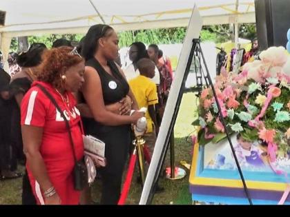 Mourners take one final look at the body of Shani Coke in Troy, Trelawny yesterday. 