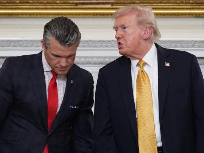 President Donald Trump talks with Defense Secretary Pete Hegseth after a roundtable on criminal cartels in the State Dining Room of the White House, October 23, 2025, in Washington. 