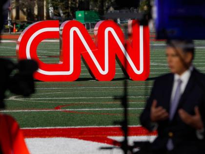 A journalist records a video near a CNN sign on an athletic field outside the Clements Recreation Centre, where CNN/New York Times hosted the Democratic presidential primary debate at Otterbein University, Monday October 14, 2019 in Ohio, USA. 
