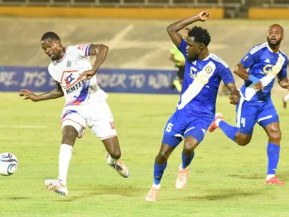 Corey Burke (left) from Portmore United, tries to get the better of Kyle Ming (centre) and Fitzroy Cummings from Mount Pleasant FA during their Concacaf Caribbean Cup match at the National Stadium. 