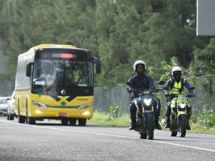 A Jamaica Urban Transit Company bus carrying third country nationals who arrived in the island on Tuesday departs from the Norman Manley International Airport in Kingston under police escort.