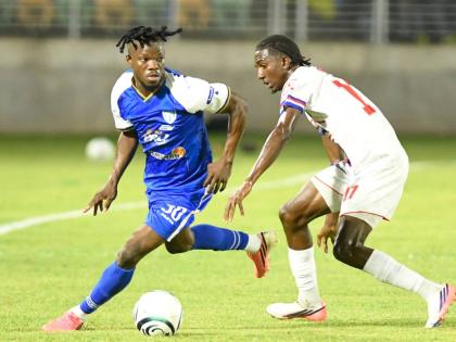 Violette FC’s Jean Vedrine (left) tries to dribble by Portmore United’s Rashaun Small during their Concacaf Caribbean Cup semi-final football match at Sabina Park yesterday.
