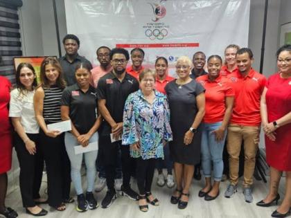 Trinidad and Tobago athletes and representatives share a photo after collecting their monetary rewards for medalling at the Central American and Caribbean  Games in Santo Domingo