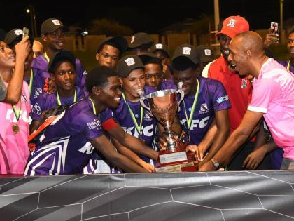 Ian Allen/Photographer 
Keith Wellington (right), President of Inter Secondary Schools Association (ISSA), Andrei Roper (second right) Marketing Manager, Restaurants of Jamaica, present the Walker Cup title to Kingston College captain, Kemaul Patterson sho