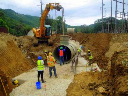 Workmen at a section of the pipeline to serve the new Maggotty Hydro Plant