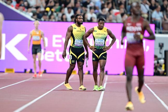 World Championships silver medallist Kishane Thompson (left) and teammate Ryiem Forde walk to the finish line, dejected men, after dropping the baton in the men's 4x100-metre heats.