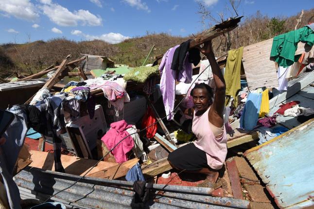 Sixty year old Juliet Clarke of Ipswich, St. Elizabeth, sits atop the rubble of her three bedrood board house after it collapsed during the passage of Hurricane Melissa.
