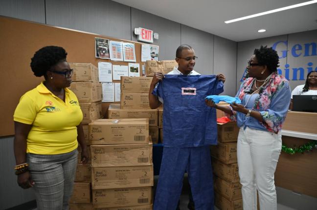 Janet Silvera (right), the chairman of the Sarah’s Children charity, presents a donation of 1,440 medical scrubs to Dr Dwayne Hall (centre), head of surgery at the Cornwall Regional Hospital (CRH) in St James, and Cassandra Laing, CRH’s operations mana