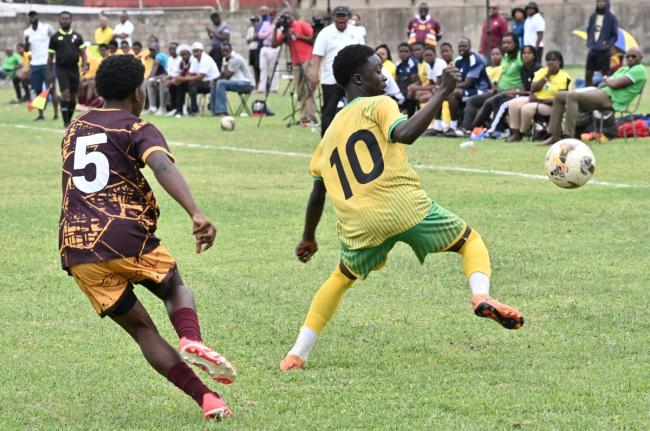Exceslior’s Matthew Murray (right) sends Wolmer’s Boys’ School’s Nilmar Stewart the wrong way during their ISSA Mighty Malt Urban U16 schoolboy football quarterfinal round game at Wolmer’s yesterday. Excelsior won 3-2 but still missed out on a se