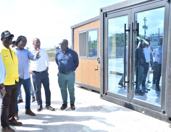 Minister of Local Government and Community Development, Desmond McKenzie (left), listens as Chief Engineering Officer at the Trelawny Municipal Corporation, Kayon Hall (second left), provides details on one of the units at the Trelawny Infirmary’s new lo