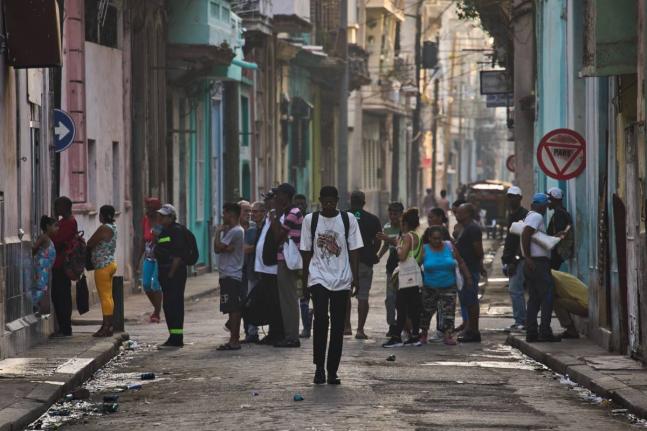 People line up in the street to buy bread in Havana, Cuba, Friday, March 13, 2026. (AP Photo/Ramon Espinosa)