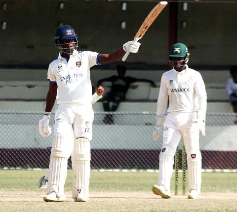 Barbados Pride’s Kevin Wickham raises his bat after scoring 150 against Jamaica Scorpions on the opening day of their West Indies Championship cricket match at Chedwin Park in St Catherine on Sunday.