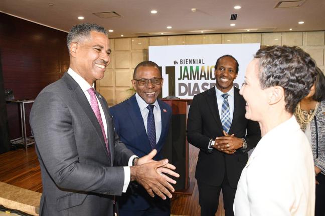 Keith Levy (left), managing director (interim) at JN Bank, makes a point to Minister of Foreign Affairs and Foreign Trade, Senator Kamina Johnson Smith (right), as she greets legacy sponsors and guests during the launch of the 11th biennial Jamaica Diaspor