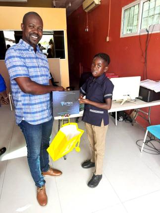 Central St Mary Member of Parliament Omar Newell presents one of 10 tablets donated by the Universal Service Fund to grade‑five student Jaleel Watson of Port Maria Primary School. 