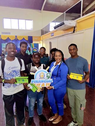 Kimblee Elliott, marketing officer at the Manchester Co-op Credit Union, takes a moment to pose with students at the Northern Caribbean University during the Reach & Teach School Tour.