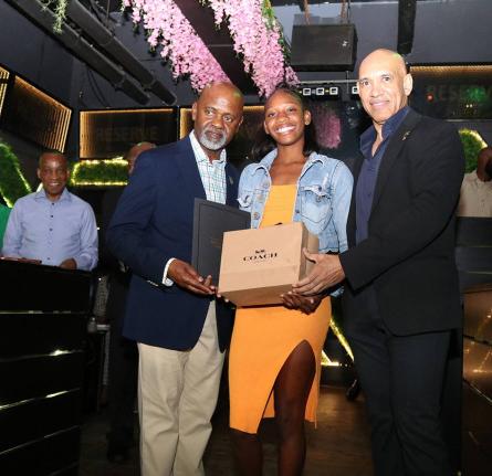 Jamaica’s Ambassador to the United States, Major General (Ret’d) Antony Anderson (right), and Team Jamaica Bickle President and CEO Irwine Clare Sr present sprint standout Shanoya Douglas of Holland High with a gift during Team Jamaica Bickle’s annua