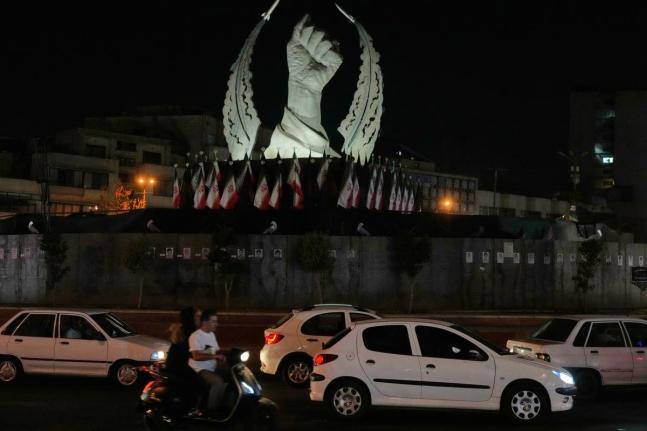 Vehicles drive past a monument depicting the clenched fist of the late Iranian Supreme Leader Ayatollah Ali Khamenei, who was killed in the US and Israel strike on February 28.