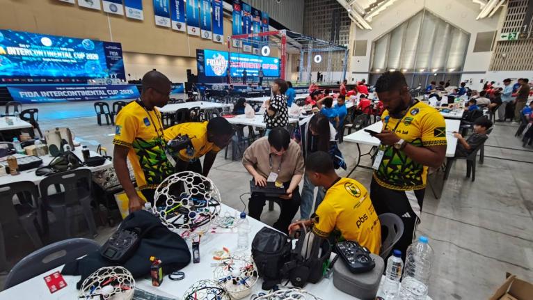 Contributed 
Jamaica Drone Soccer team members get some help from the South Korean team, who provided valuable assistance in resolving software issues during the Federation of International Drone soccer Association (FIDA) Intercontinental Cup in South Kore
