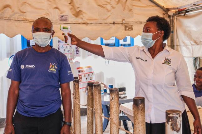 In this file photo, a health worker checks an individual’s temperature at a temporary health clinic at the Mpondwe border crossing linking Uganda and the Democratic Republic of the Congo, on Thursday, June 4, 2026.