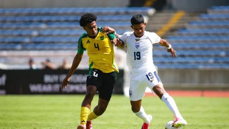 Jamaica's  Dante Plunkett (left) battles for the ball with Raheen
Cuello of Panama during their  Concacaf U-20 Championship Group C match in Puebla, Mexico on Wednesday night. The match ended in a 2-2 draw.