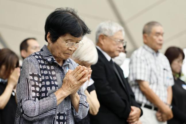 People observe a minute of silence during a ceremony to mark the 81st anniversary of the US atomic bombing at the Peace Park in Nagasaki, southern Japan.