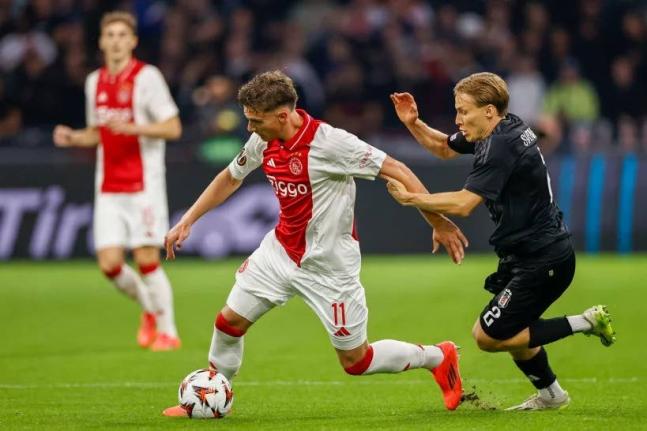 Ajax’s Mika Godts (left) duels for the ball with Besiktas’ Jonas Svensson during the Europa League  match between Ajax and Besiktas, at the Johan Cruyff Arena, in Amsterdam, Netherlands, on September 26, 2024. 