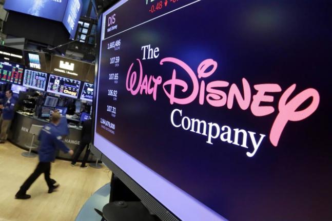 In this August 8, 2017, file photo, The Walt Disney Co. logo appears on a screen above the floor of the New York Stock Exchange. (AP Photo/Richard Drew, File)