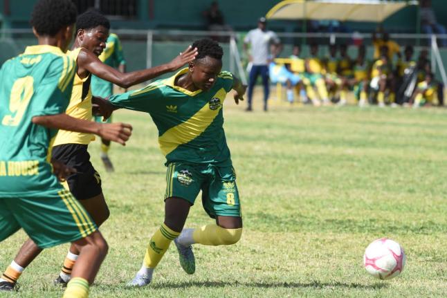 Nichwayne Patrick (right) from Excelsior High School and Jerome McCarthy (centre) from Kingston Technical High compete for the ball during their Ali Cup football match played at Excelsior High School last Thursday.