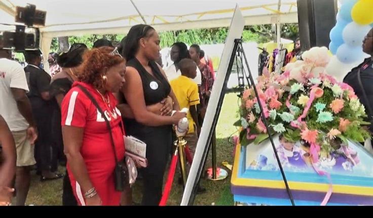 Mourners take one final look at the body of Shani Coke in Troy, Trelawny yesterday. 