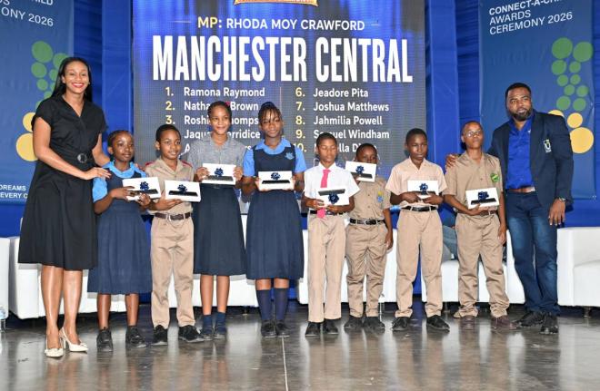 State Minister in the Ministry of Education, Skills, Youth and Information and Member of Parliament for Manchester Central Rhoda Moy Crawford, shares a photo opportunity with students from her constituency as they display tablets received during the Univer