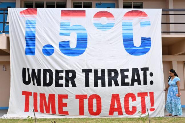 A climate change banner is unfurled by Greenpeace during the Pacific Islands Forum Leaders Meeting in Koror, Palau.
