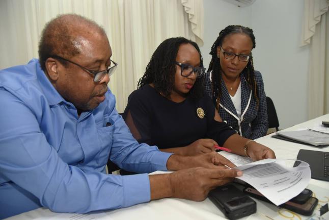 Trade unionist Lambert Brown (left) goes through documents with Dr Jubilee Brown-Service (centre), president of the Jamaica Medical Doctors' Association (JMDA) and Dr Renee Badroe (right), Immediate Past President of the JMDA, during a press conference at 
