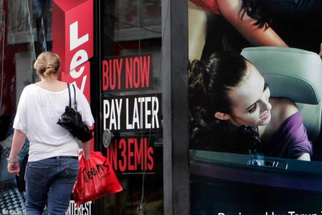 AP
A woman walks by a sign ‘Buy now pay later’ at a store in Bangalore, India, on September 10, 2009.