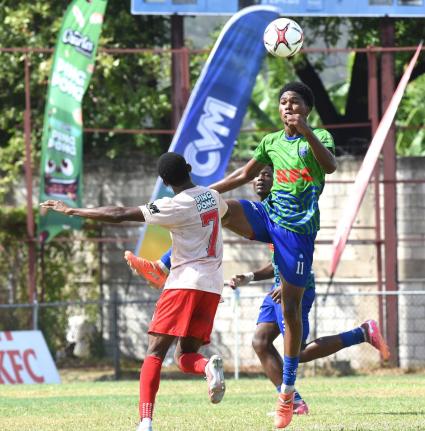 Niquan Allen (left) of  Mona High is outjumped for the ball by Kyle Chen (right) of Vauxhall High during their Walker Cup football quarter-final match at  Drewsland Mini Stadium in Kingston last  Saturday.