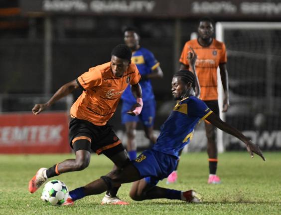 Racing United’s Damion Herrera (right) tackles Tivoli Gardens’ Dwayne Atkinson during a Jamaica Premier League football match at the Waterhouse Stadium yesterday. Racing won the game 4-3.