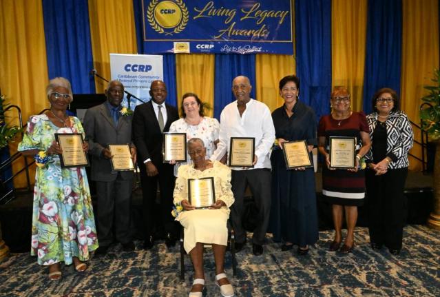 Minister of Labour and Social Security Pearnel Charles Jr. (third left) and Caribbean Community of Retired Persons (CCRP) Founder and Executive Chair,Jean Lowrie-Chin (right), share a moment with the seven recipients of the CCRP 2026 Living Legacy Awards d