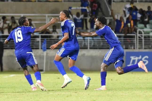 Mount Pleasant’s Nickalia Fuller (centre) celebrates with teammates Warner Brown (left) and Kyle Ming after scoring in yesterday’s Caribbean Cup semi-final football match against Trinidad and Tobago’s Club Sando at Sabina Park.