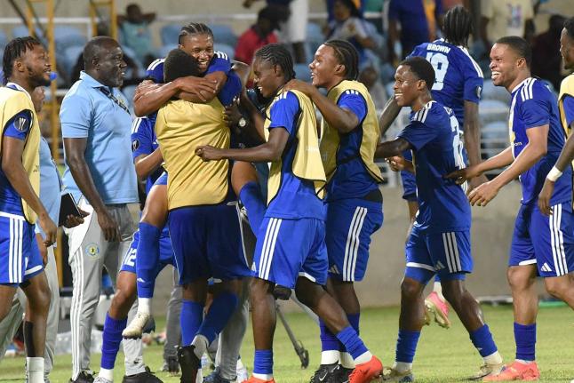  Mount Pleasant head coach Theodore Whitmore (second left) looks on as his players celebrate their second goal against Club Sando of Trinidad and Tobago at Sabina Park on Thursday night. 