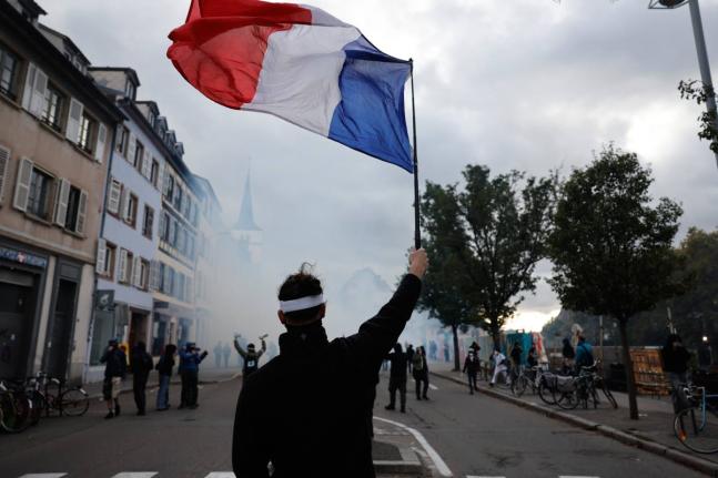 A protester holds a French flag during a demonstration against rising living costs in Strasbourg, France.