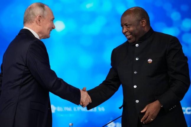 Russian President Vladimir Putin (left) and Burundi’s President Evariste Ndayishimiye shake hands during the plenary session of the Russia-Africa Summit in Moscow, Wednesday.